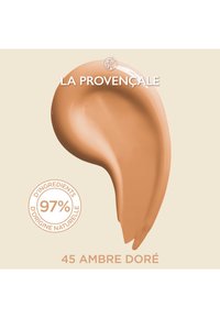 Crème beige avec une texture lisse, présentant une forme de goutte. L'étiquette indique "45 Ambre Doré" et "97 % d'ingrédients naturels."