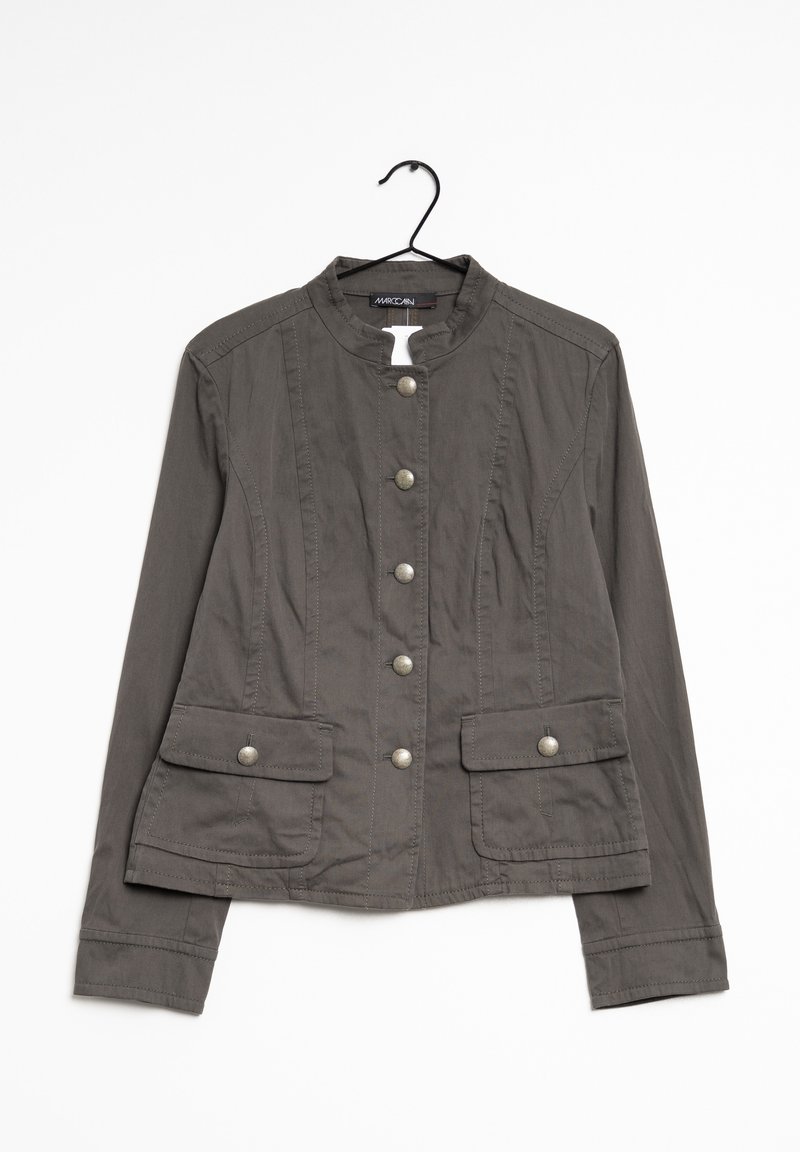 Veste boutonée gris foncé à manches longues, deux poches à rabat à l'avant et un col sans col suspendue sur un cintre noir.