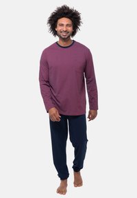 Bordeaux langemouwen shirt met horizontale strepen en een klein zakje, gecombineerd met marineblauwe broek, beide vervaardigd uit zachte stof.