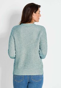 Hellblaue, gerippte Strickjacke mit Rundhalsausschnitt, langen Ärmeln und lockerem Schnitt. Texturiert mit einem dezenten Glanz, keine sichtbaren Muster.