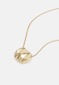 Collier avec pendentif en or au design lisse et arrondi, attaché à une fine chaîne. Présente des lignes courbes et une finition brillante.