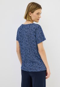Korte mouwen t-shirt in marineblauw met een contrasterend blauw abstract bladpatroon; zachte stof, ronde halslijn, casual fit, heuplange snit.