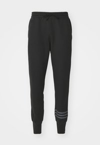 Pantaloni della tuta neri in cotone con elastico in vita, coulisse, gambe affusolate e tre strisce grigie vicino alla caviglia. Texture morbida.