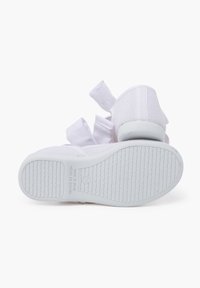 Zapatillas deportivas blancas con parte superior de malla, suela de goma plana y acentos de tela. Presentan una suela texturizada para mejor agarre. Fabricadas en España.