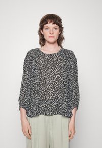 Blusa preta com pequeno padrão floral em branco e roxo, corte solto, decote redondo e mangas de três quartos, feita de tecido leve.