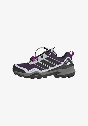 Zapatilla de trail en púrpura y gris con una parte superior texturizada, acentos en negro, una suela de goma y un sistema de cordones rápido para un ajuste seguro.