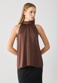 Koffiekleurige, mouwloze blouse met een hoge, geplooide halslijn en een vloeiende uitstraling. Gemaakt van gladde, lichte stof, met een rechte zoom.