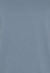 Maglietta di cotone azzurra, a maniche corte, tessuto liscio, scollo rotondo standard, senza motivi o decorazioni, design semplice.