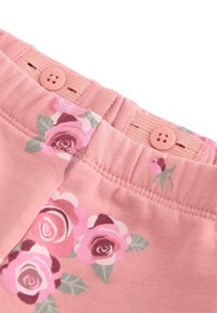 Vaaleanpunaiset puuvillashortsit, joissa on koristeellinen kukkakuosi vaaleanpunaisen ja vihreän sävyissä. Vyötäröllä neljän napin suljenta.