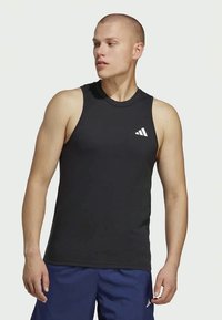 Schwarzes Sporttanktop mit rundem Halsausschnitt und ärmellosem Design. Mit einem weißen Adidas-Logo auf der oberen linken Seite.