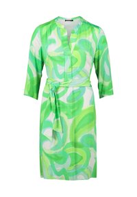 Grünes und weißes Kleid mit einem Bindegürtel, das über einen V-Ausschnitt und Dreiviertelärmel verfügt und mit einem Wirbelmuster verziert ist. Glatte Stofftextur.