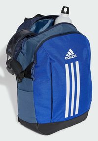 Mochila azul con un acabado texturizado, con una base negra, correas ajustables y tres rayas blancas en un lado. Incluye una botella de agua.