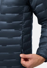 Blauer Puffer-Jacke mit einem gesteppten Design in horizontalen Abschnitten, Stofftextur und einem seitlichen Reißverschluss mit einer Zuglasche.