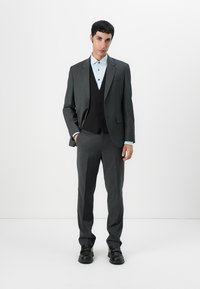 Gray tailored suit with a slim fit, featuring a black vest, light blue shirt, and shiny black shoes. Smooth fabric and structured design.