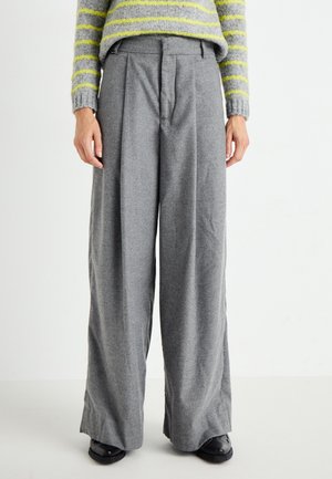 Gray, wide-legged trousers with front pleats, made of soft fabric. Features a zip closure and belt loops, paired with black footwear.