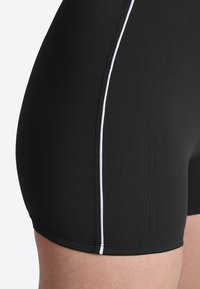 Schwarze Badshorts mit einer glatten Textur, einem kontrastierenden weißen Seitenstreifen und einer figurnahen Passform für Komfort und Funktionalität.