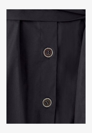 Black fabric with a smooth texture, featuring two silver metal buttons with four holes each, and a folded waistband.