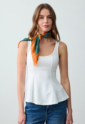 Witte mouwloze peplumtop met rechte halslijn en zijnaden. Gecombineerd met een kleurrijke zijden sjaal die om de hals is geknoopt. Casual look.