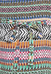 Multikleurige stof met diverse geometrische patronen; bevat zigzaglijnen, lijnen en stippen; taillekoord in levendige tinten.