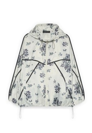 Hvid hættetrøje med sorte blomsterprint og sorte kantdetaljer, lynlås foran og justerbare snore ved kant og hætte.