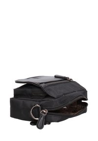 Borsa in tessuto nero con due scomparti con zip, superficie testurizzata e un accento in metallo. Presenta una chiusura a pattina e una fodera interna marrone.