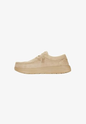 Beige suède veterschoen met een ronde neus, gestikte details, een zachte textuur en een gewatteerde kraag; heeft een dikke, flexibele zool.