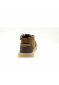 Stivale alla caviglia in camoscio marrone con suola in gomma beige, caratterizzato da un tallone posteriore in pelle scura testurizzata e una fodera a motivi in contrasto.