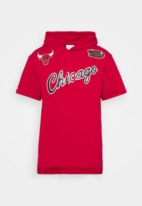 Sudadera roja con capucha y mangas cortas, gráfico de Chicago en blanco, y parches incluyendo un logo de toro y un emblema de las Finales de la NBA. Material de algodón.