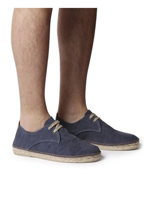 Navy canvas espadrilles with a textured surface, jute sole, and beige laces. Features a side cutout design near the ankle.