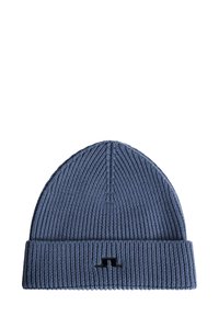 Blå stickad mössa med ribbad struktur och uppvikt kant, med en liten svart logotyp på framsidan.