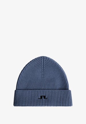 Blauwe gebreide beanie met een geribbelde textuur en een omgeslagen boord, met een klein zwart logo aan de voorkant.