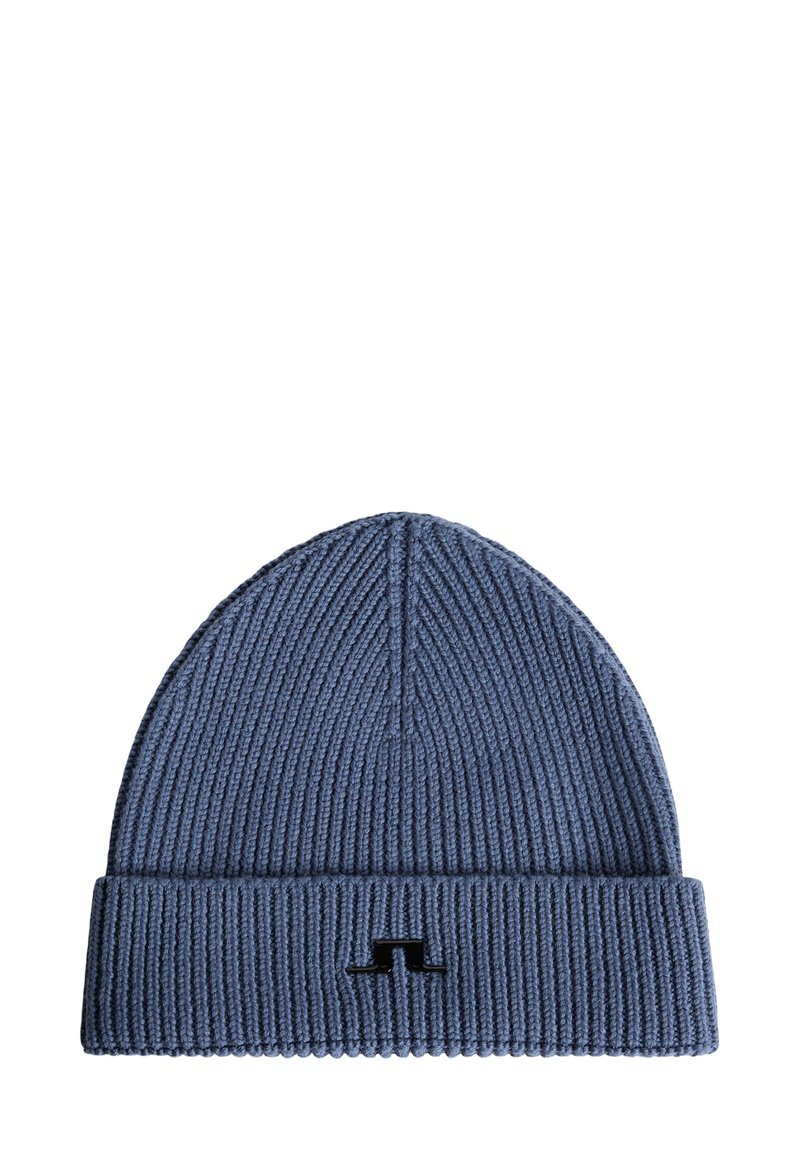 Blå stickad mössa med ribbad struktur och uppvikt kant, med en liten svart logotyp på framsidan.