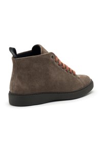 Stivaletti in suede marrone con suola in gomma nera, dotati di lacci marroni e di una linguetta sul retro per un facile utilizzo. Texture liscia, design minimalista.