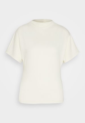 Short-sleeve cream-colored top made of soft fabric, featuring a round neckline and relaxed fit. No visible patterns or embellishments.