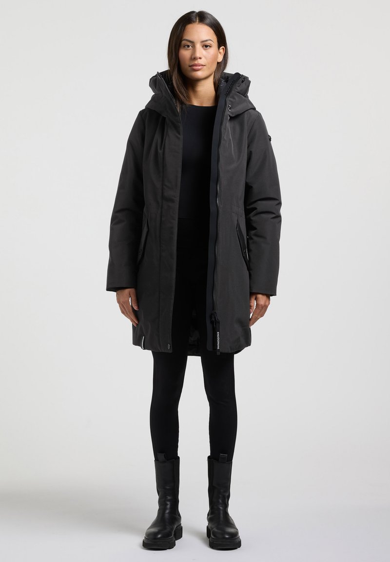 Svart parkas med dragkedja fram, justerbar huva och sidofickor. Har en avslappnad passform och slät textur, i kombination med snygga svarta leggings och stövlar.