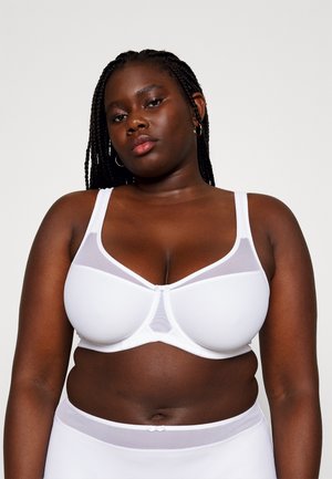 White bra with mesh panels, underwire support, adjustable straps, and a smooth texture; features a bow accent at the center front.