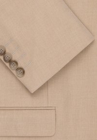 Karmelowy żakiet o gładkiej teksturze, z wykładanym kołnierzem, pięcioma okrągłymi brązowymi guzikami oraz jedną kieszenią na piersi z subtelnymi detalami ściegów.