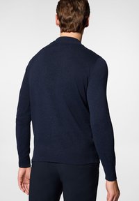 Granatowy sweter dzianinowy z długimi rękawami, ściągaczami na mankietach i dolnej krawędzi, z okrągłym dekoltem i gładką teksturą, widok od tyłu.