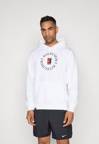 Bela kapuco iz kombinacije bombaža, s krožnim logotipom NikeCourt na sprednji strani, sprednjim kengurujskim žepom in rebrastimi manšetami.