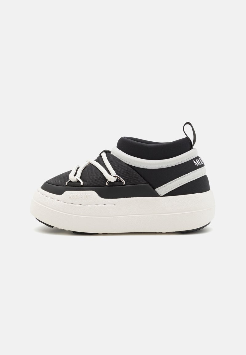 Sneaker bianco e nero con tomaia imbottita, lacci bianchi, punta rotonda e suola spessa bianca con un branding in rilievo discreto.