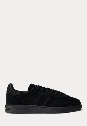 Sneaker in suede nero con suola piatta in gomma, dotate di pannelli testurizzati, design con lacci e un logo discreto sul lato.