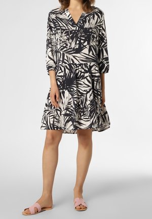 Robe à motifs floraux bleu marine et crème, avec un décolleté en V et des manches trois-quarts. Associée à des sandales à glissière roses.