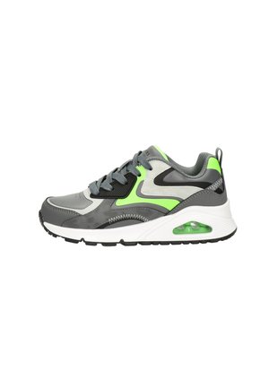 Scarpa da ginnastica grigia con un accento verde neon, sovrapposizioni testurizzate, suola ammortizzata con un'unità d'aria visibile e suola in gomma nera.