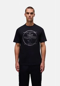 Black cotton t-shirt with short sleeves, featuring a circular graphic design that includes text and a globe pattern on the front.