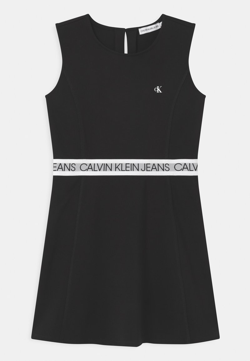 Robe noire sans manches avec encolure ronde, ceinture blanche imprimée de "Calvin Klein Jeans," et petit logo blanc CK sur la poitrine.