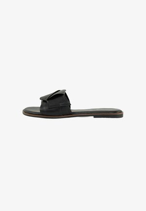 Schwarze Leder-Sandalen mit breitem Riemen und gefaltetem Detail, offener Zehenbereich, flache Sohle und genähte Akzente.