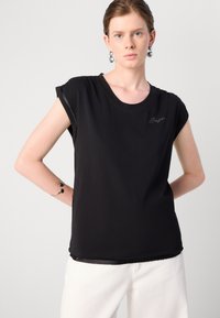 Juodas trumpa rankovė T-shirt su apvalia iškirpte, pasižymintis elegantišku dizainu ir subtiliu siuvinėjimu. Pagamintas iš švelnios medžiagos.