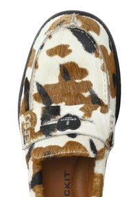 Bruine en witte koeienprint loafers met een zachte, gestructureerde afwerking, voorzien van een zwarte knop met de merknaam op de band.