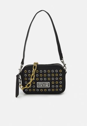 Sac à main rectangulaire noir avec œillets dorés et argentés, détail en chaîne dorée, bandoulière réglable et patch logo Versace Jeans Couture.