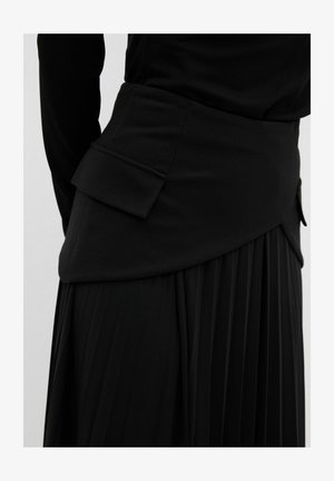 Black pleated skirt with a structured waist, featuring a side pocket and smooth texture. The design includes a layered look at the top.
